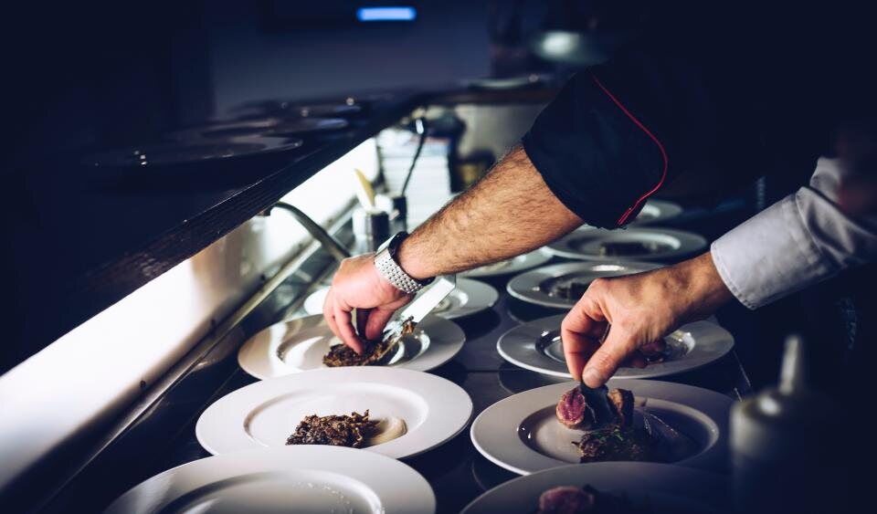 Dos cocineros emplatando en el pase de la cocina de Vespra