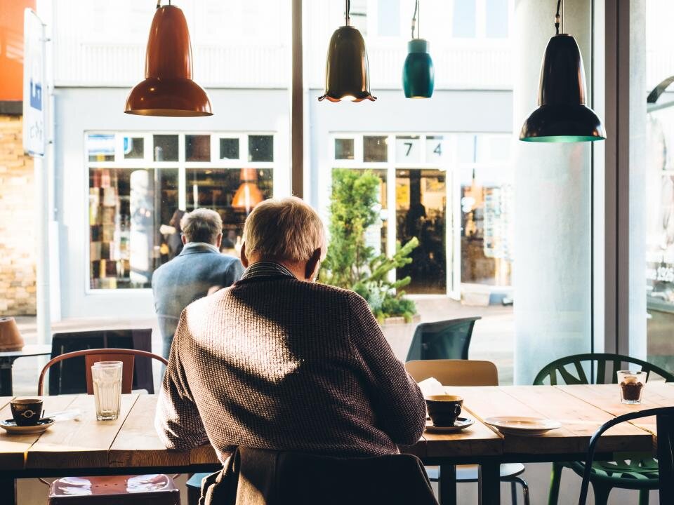 Clientes desayunando junto al ventanal de Ruda
