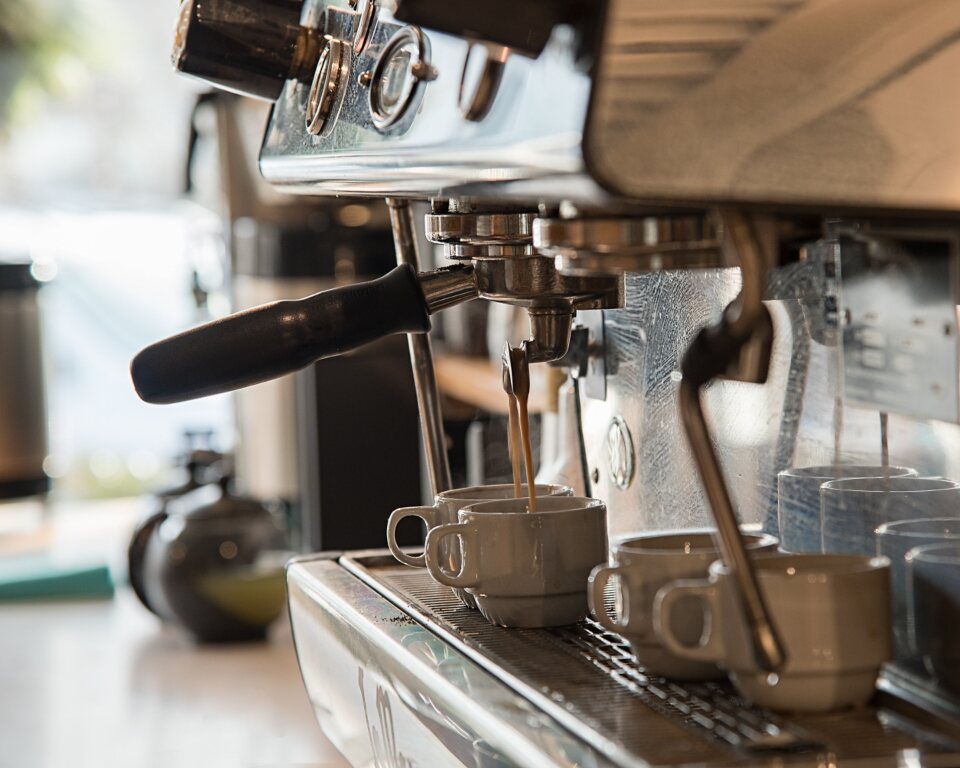 Máquina de espresso y tazas preparadas en la barra de Ruda