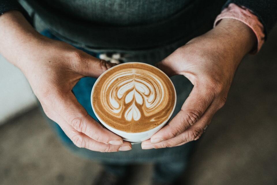 Café con leche con arte latte servido en taza de cerámica