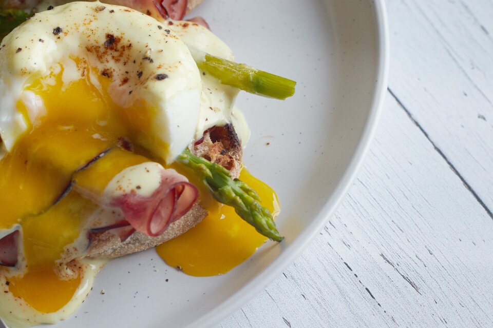 Huevos benedictinos con espárragos verdes sobre pan tostado