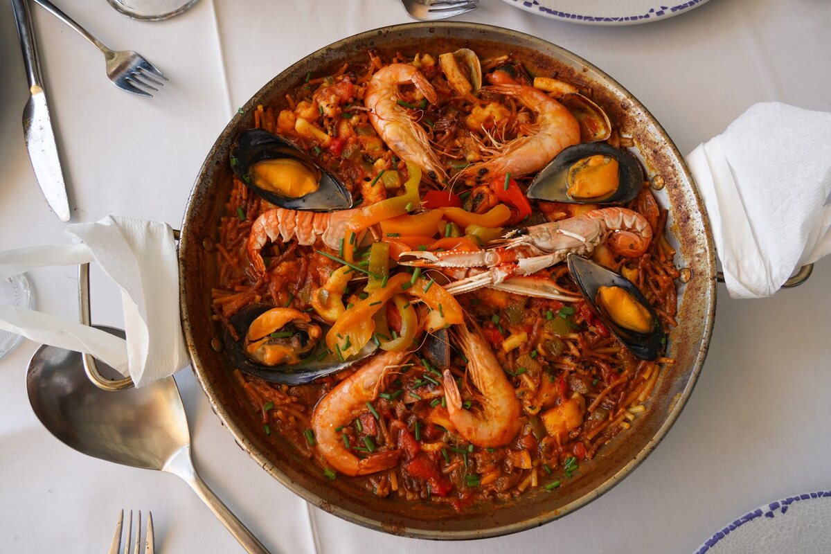 Arroz caldoso de marisco servido en la paellera